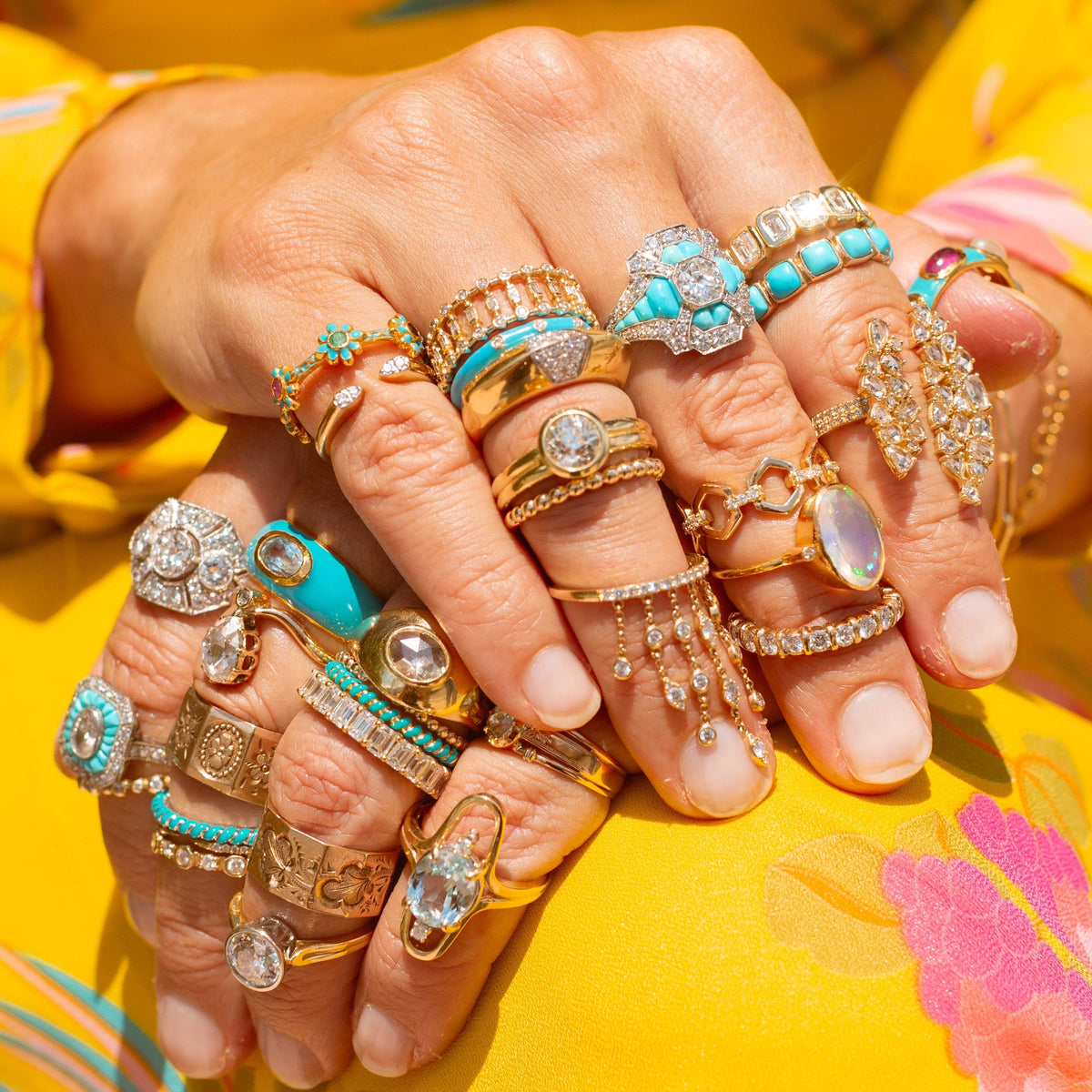 Hands stacked with colorful Dora Mae rings